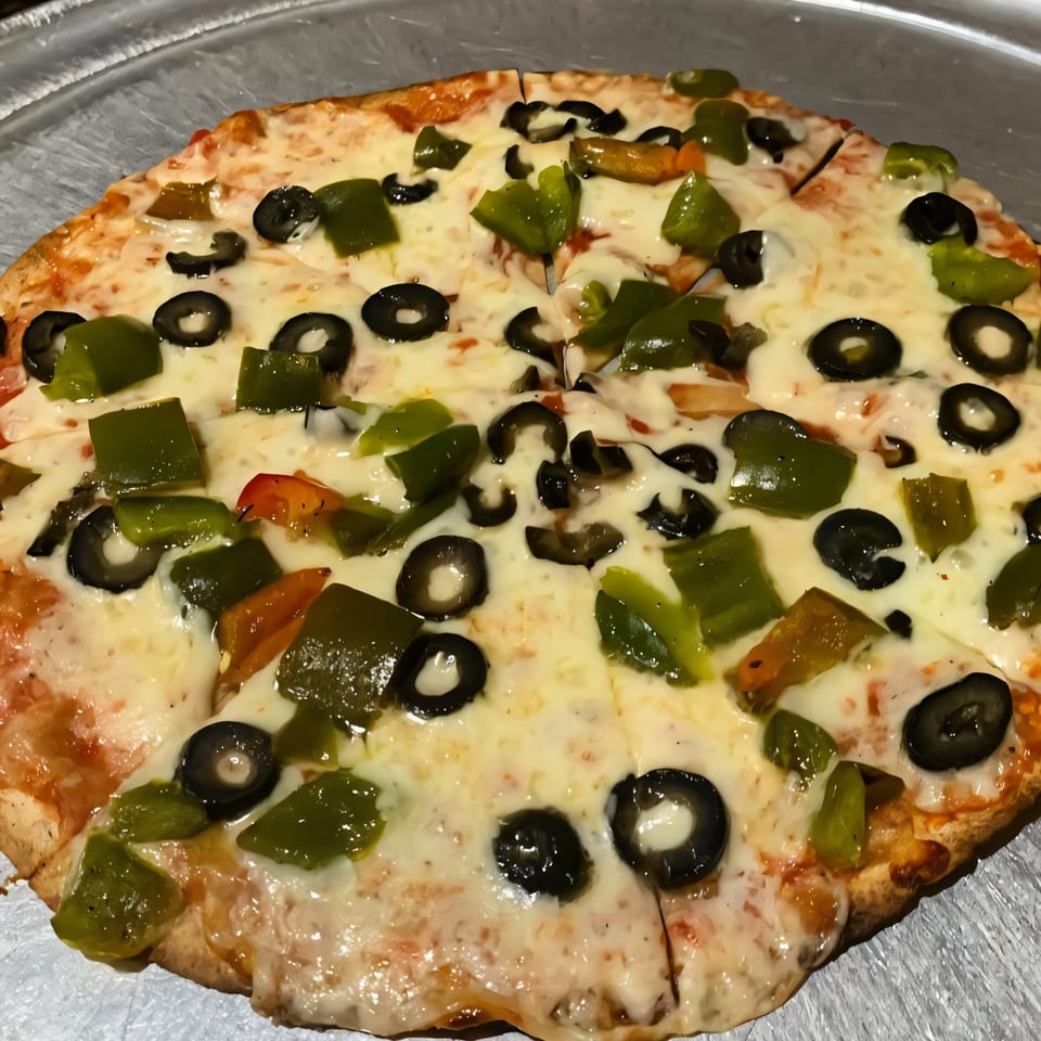 Via Roma Pizza with melted cheese, green bell peppers, and black olives on a metal tray.